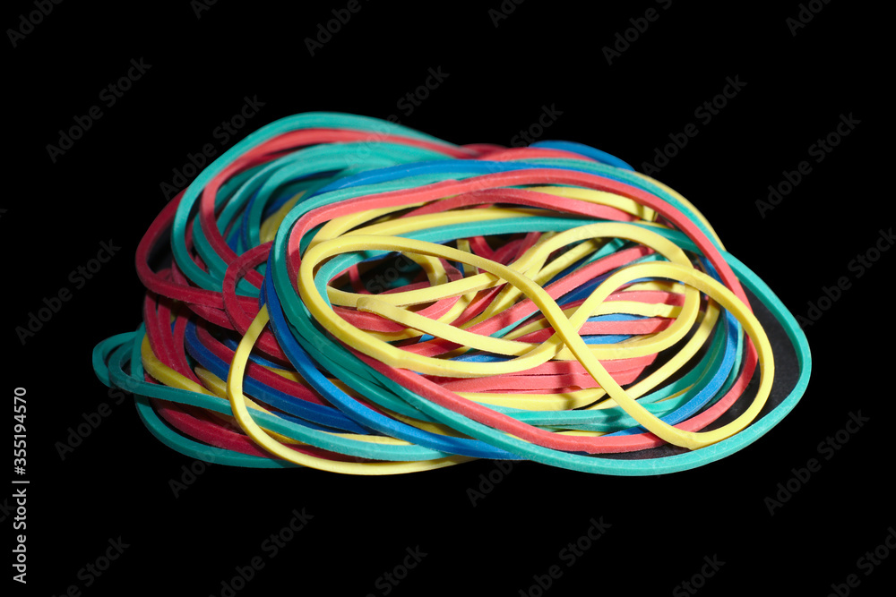 Heap of rubber bands on black background.