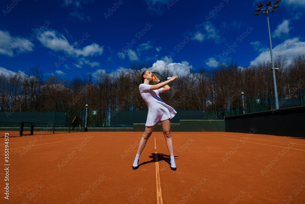 Happy beautiful sexy girl playing tennis on the court. Sport and recreation, leisure
