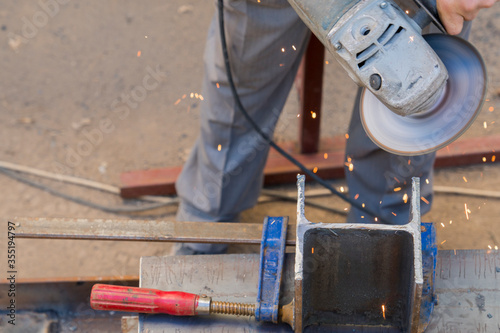 The iron hand of the worker with sander