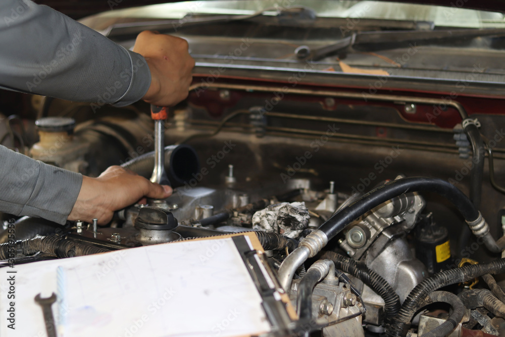 The mechanic is checking the engine. The mechanic is checking the engine.