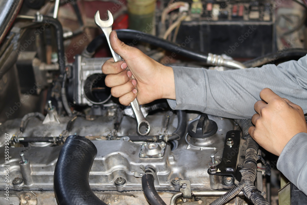 The mechanic is checking the engine. The mechanic is checking the engine.
