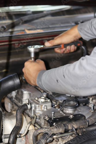 The mechanic is checking the engine.