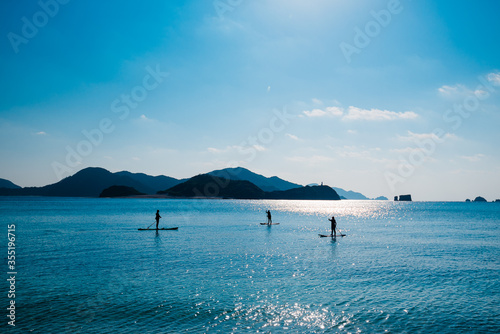 group of paddle surfers on the water with mountains in background