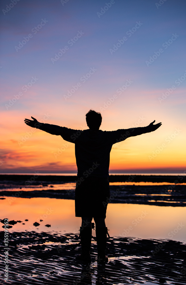 Silhouette of a man enjoying a beautiful sunrise