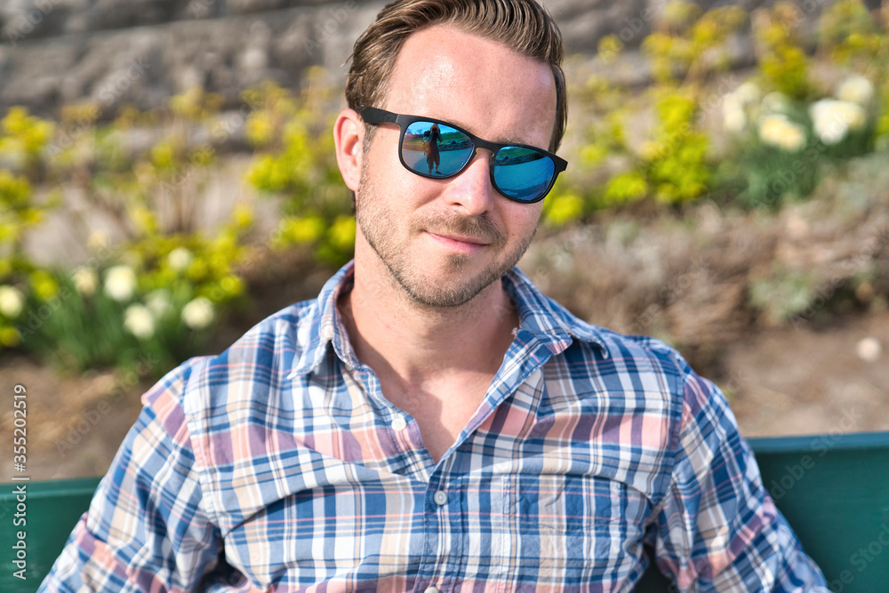 portrait of a trendy young man in the city sit on bench portrait of a trendy young man in the city sit on bench