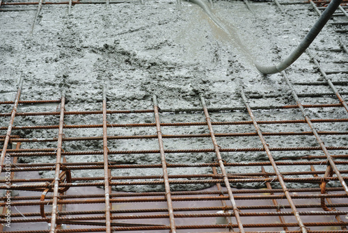 Photography SELANGOR, MALAYSIA -JUNE 18, 2016: Construction workers using a concrete vibrator at the construction site to compact the concrete slurry that pours in the formwork