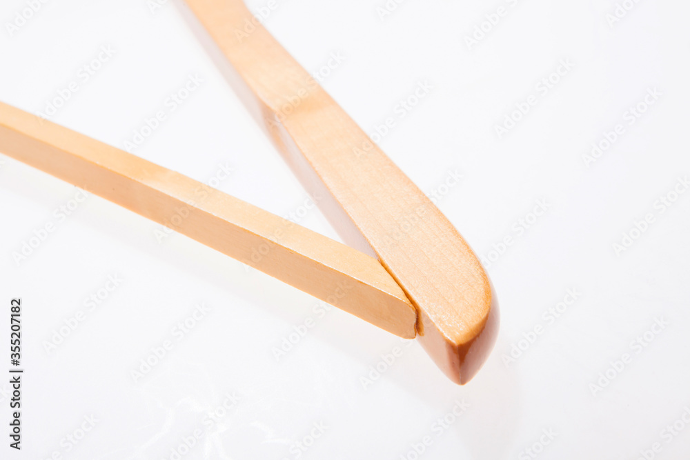 Single white wooden hanger isolated over the white background Single white wooden hanger isolated over the white background