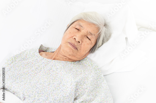 palliative care,  old Asian patient sleep on white bed, she feeling lonely, necklace old female, mother's day, elderly healthcare promotion