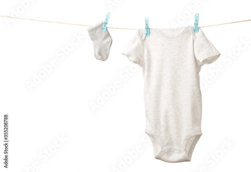 Baby clothes hanging on the clothesline isolated on white.