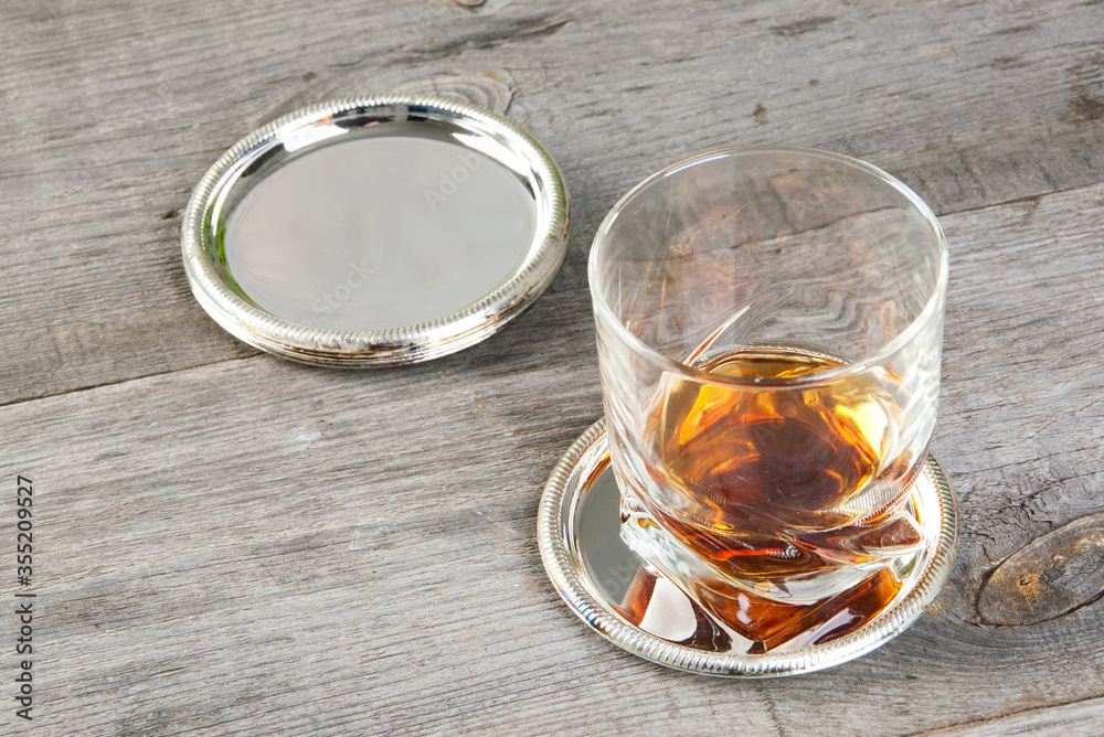 Antique silverplated coasters on wooden background. Antique silverplated coasters on wooden background.