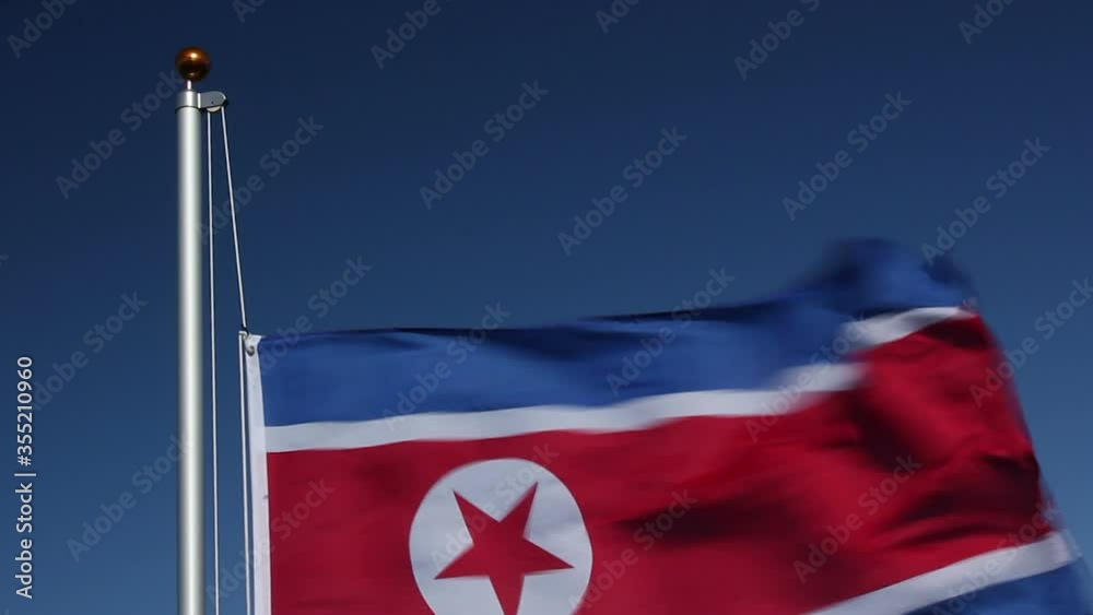 Raising the North Korea Flag flying in the wind with Blue Sky  - North Korean. Stock Video Clip Footage
