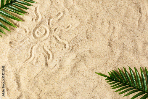 Drawing of sun on golden beach sand top view.