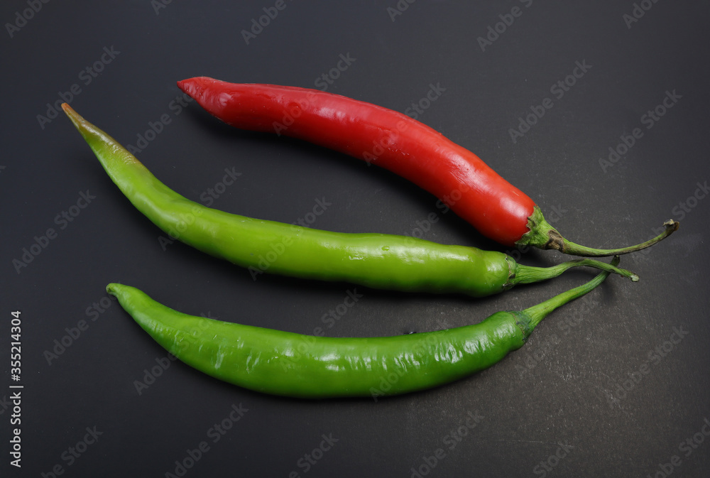Red and green chillies on a black background