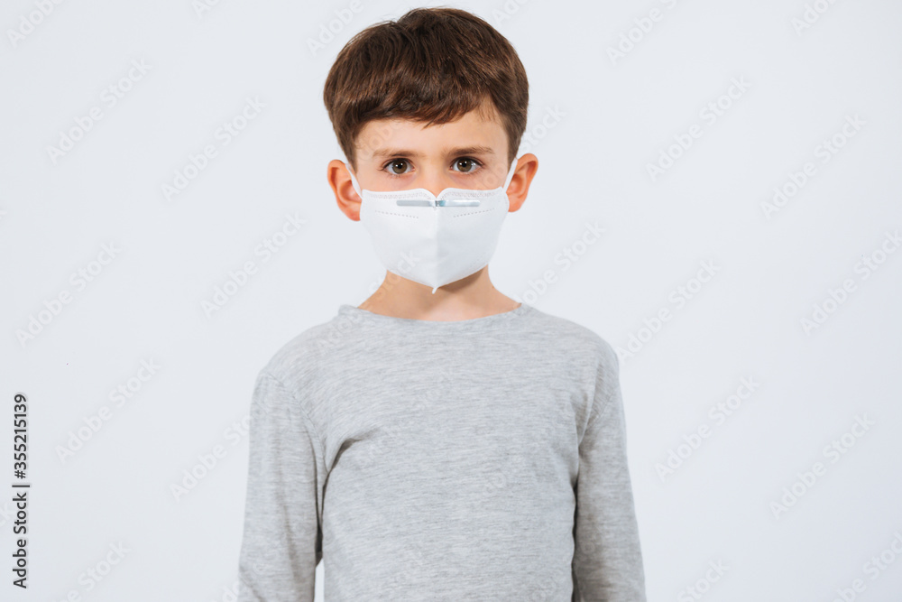 Kid putting on a face mask in a white background Kid putting on a face mask in a white background