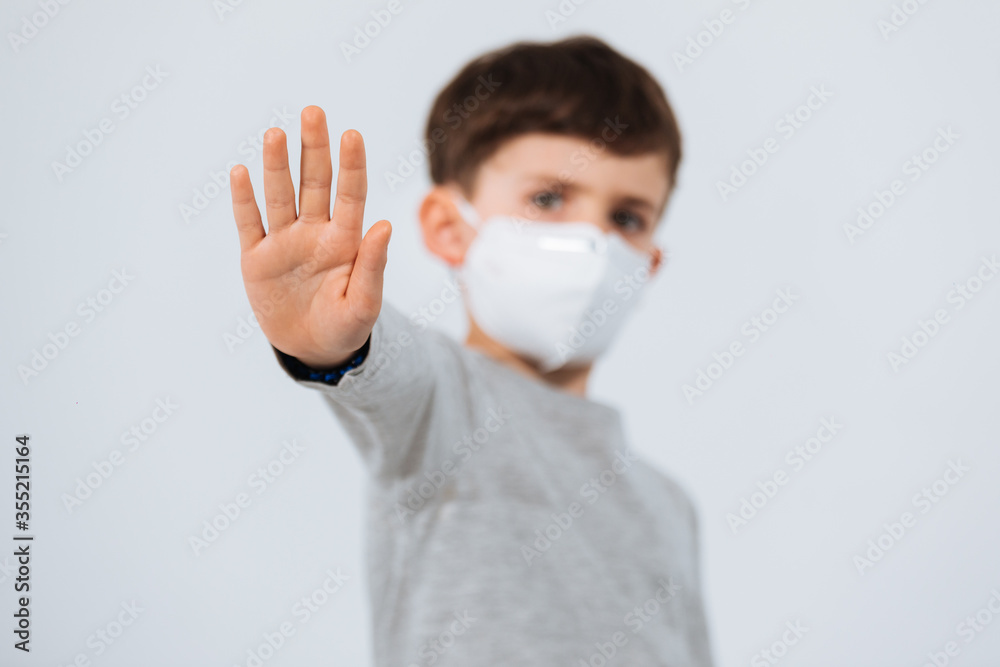 Kid putting on a face mask in a white background Kid putting on a face mask in a white background