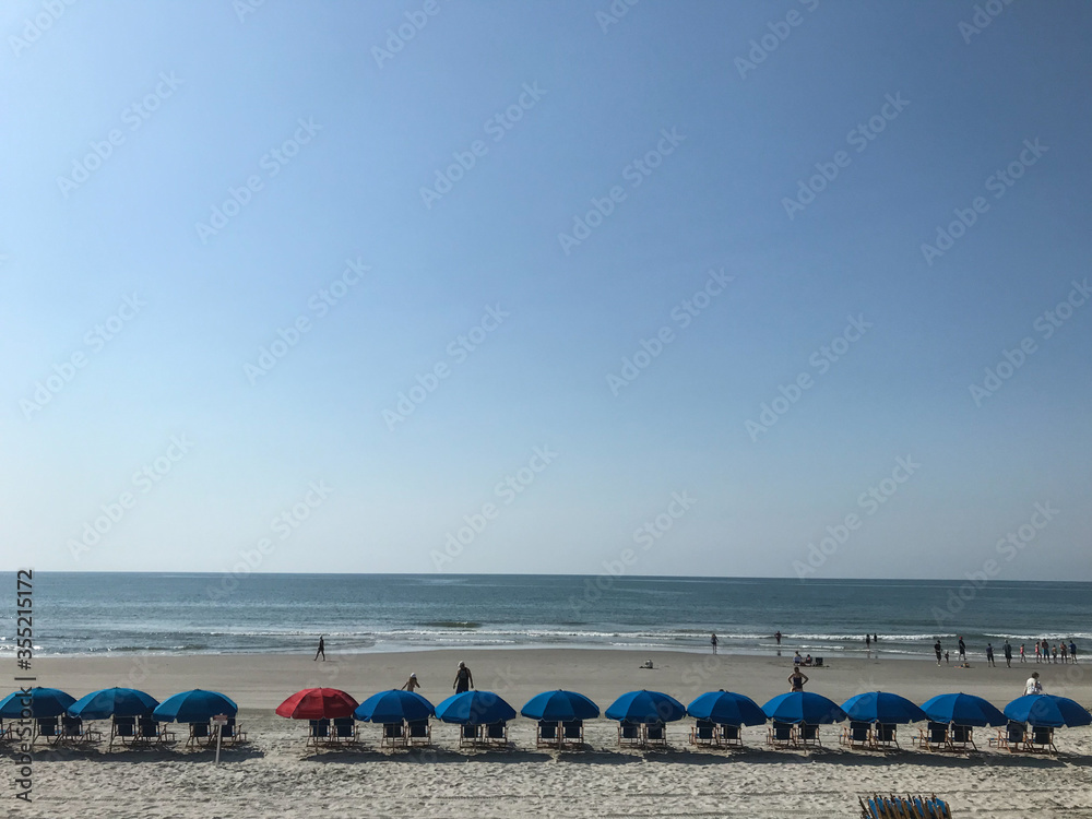 people on the beach with umbrellas people on the beach with umbrellas
