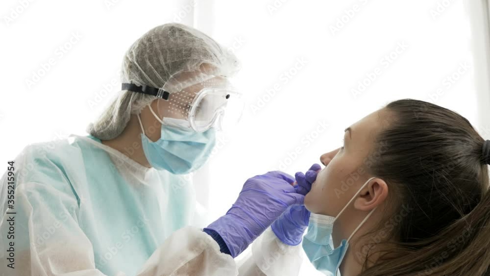 Nasal vaccination. Medical staff in a protective suit administers a vaccine through a nose to a young patient. Covid-19. Nasal vaccination. Medical staff in a protective suit administers a vaccine through a nose to a young patient. Covid-19.