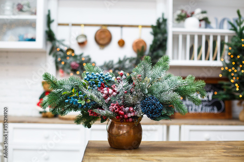 Natural Christmas composition from spruce branches and berries in the kitchen
