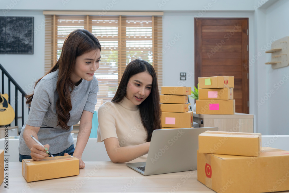 Young beautiful Asian couples woman working at home together. Portrait of young Asian online selling, shopping or preparing parcel, box to delivery. Young Asian businesswoman live streaming at home. Young beautiful Asian couples woman working at home together. Portrait of young Asian online selling, shopping or preparing parcel, box to delivery. Young Asian businesswoman live streaming at home.