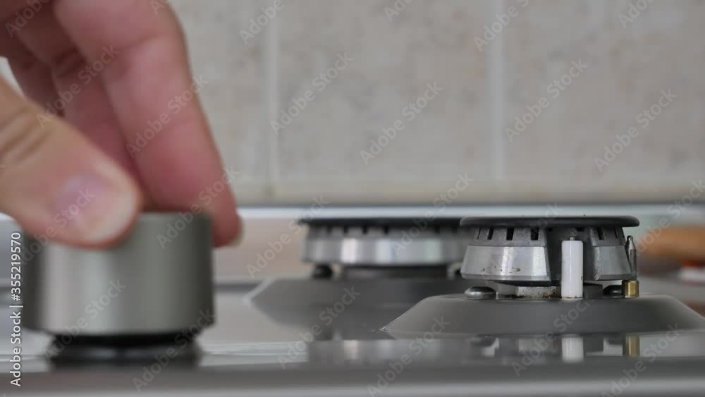 Switching on the gas cooker. Female's hand turning on the gas on a