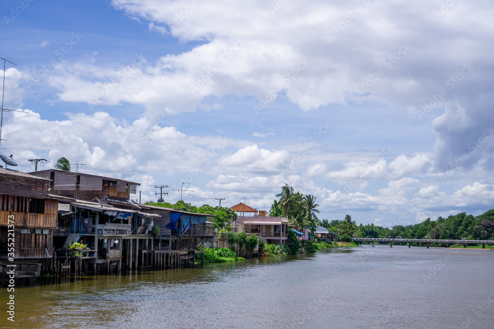 A house by the river near the mountains and blue sky