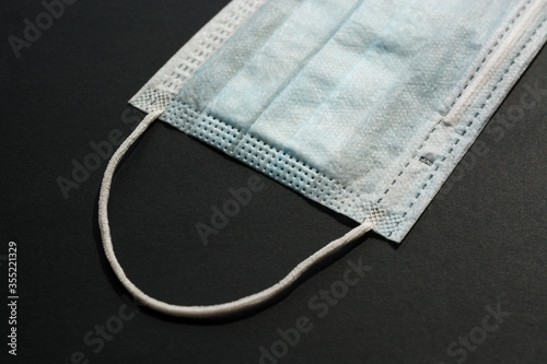 Disposable medical face mask on a black background
