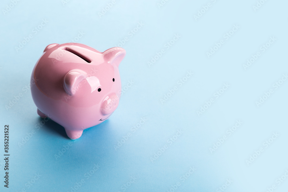 pink piggy bank on blue background.  The concept of saving money or savings, investment