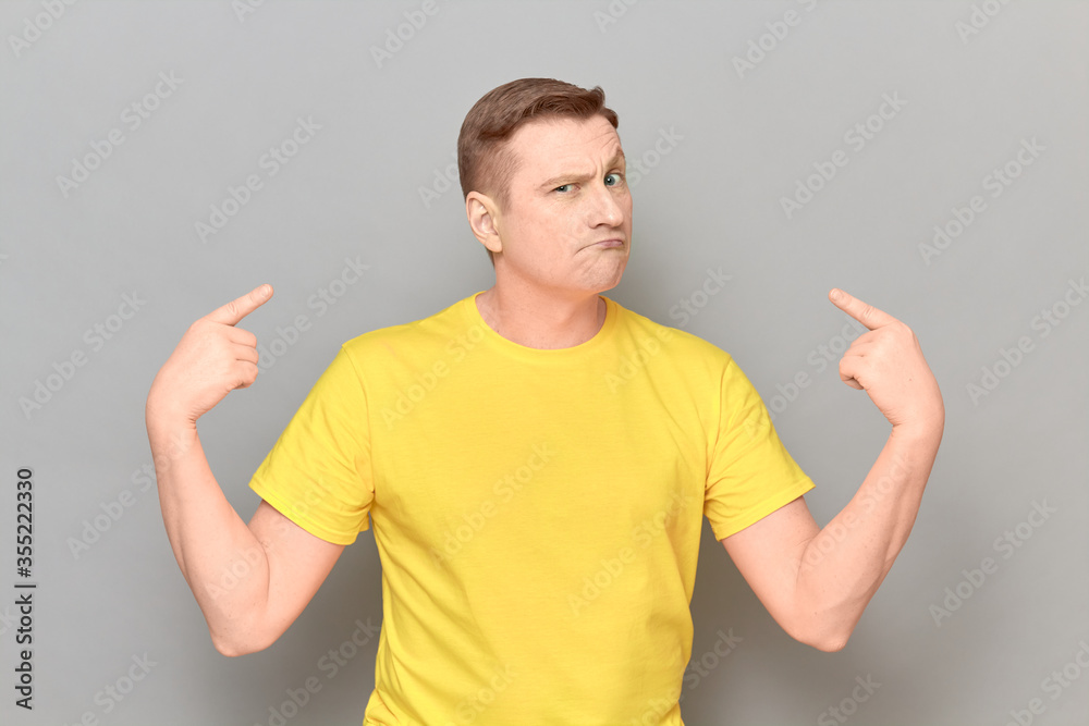 Portrait of funny proud man pointing with index fingers at himself Portrait of funny proud man pointing with index fingers at himself