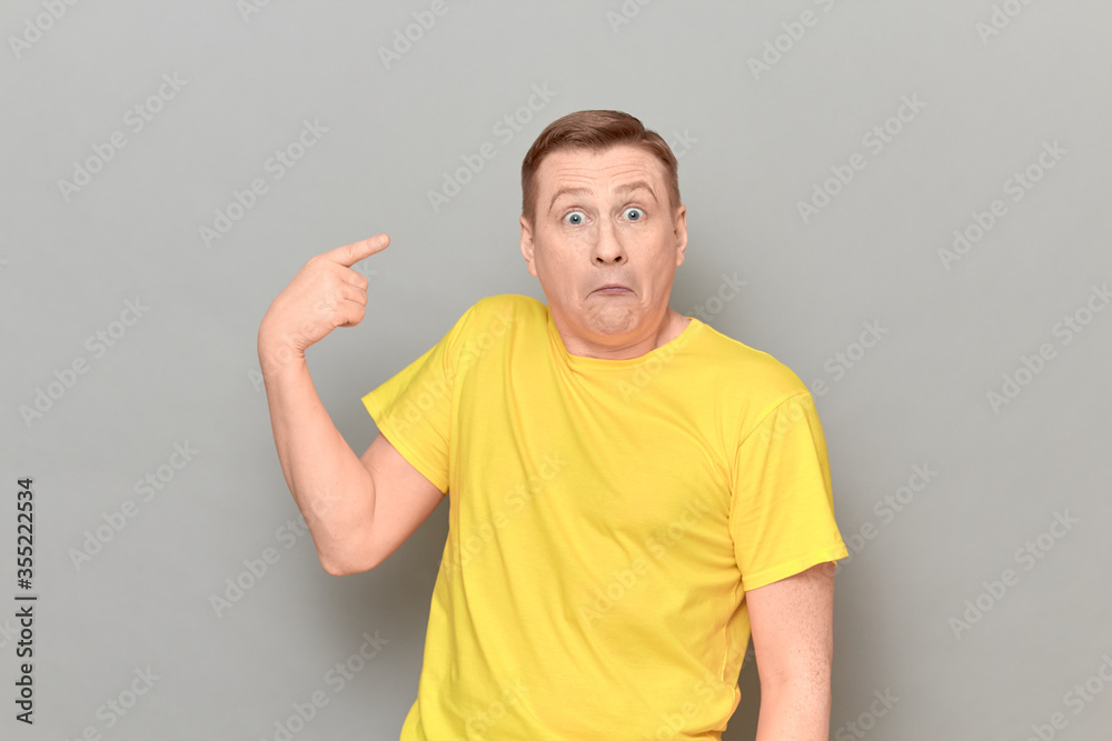 Portrait of funny perplexed man pointing with index finger at himself Portrait of funny perplexed man pointing with index finger at himself