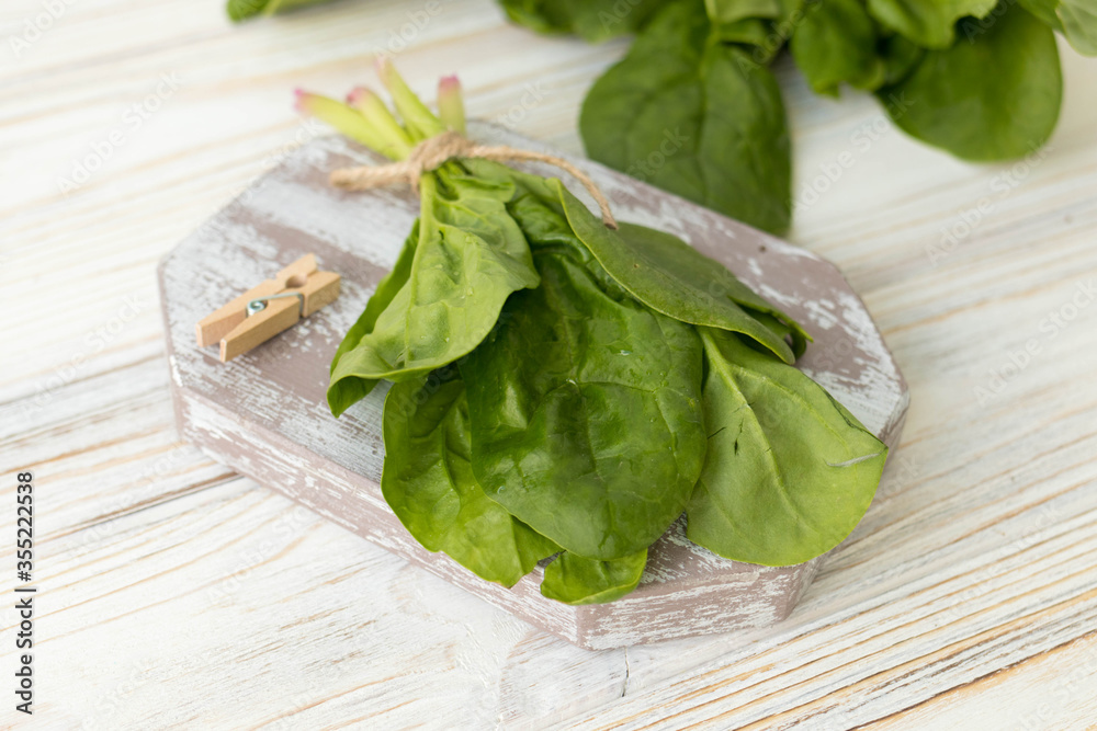 A bunch of fresh organic spinach, spinach on a wooden board A bunch of fresh organic spinach, spinach on a wooden board
