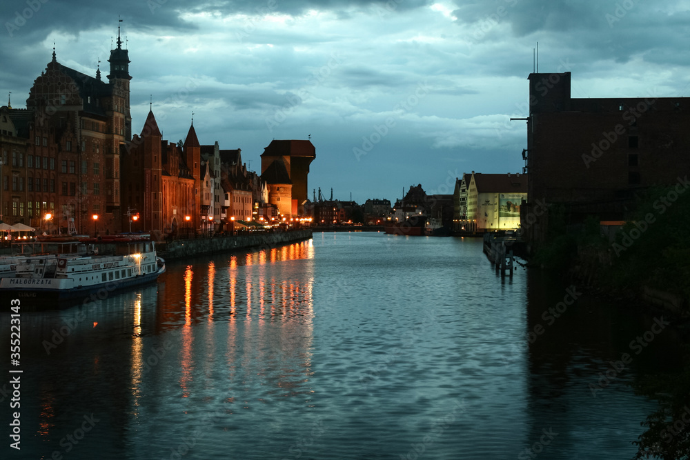 Waterfront of the Martwwa Wisla Vistula river with Medieval houses of the baltic architecture in the Srodmiescie district of Gdansk at night