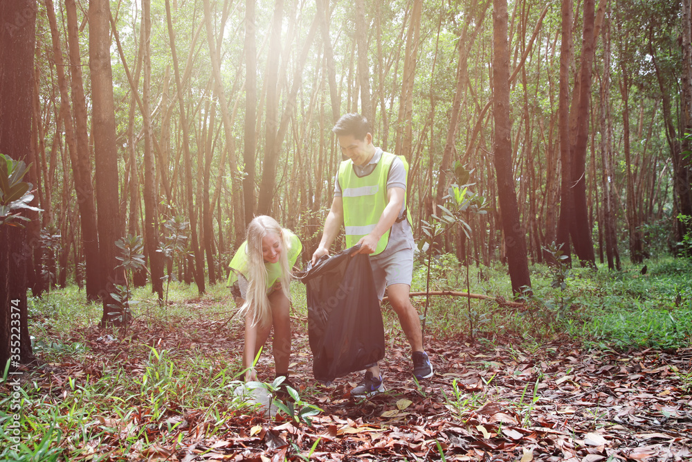 Two volunteers do CSR garbage collection at public forest, Social Responsibility and waste activity on Wold Environment day Two volunteers do CSR garbage collection at public forest, Social Responsibility and waste activity on Wold Environment day