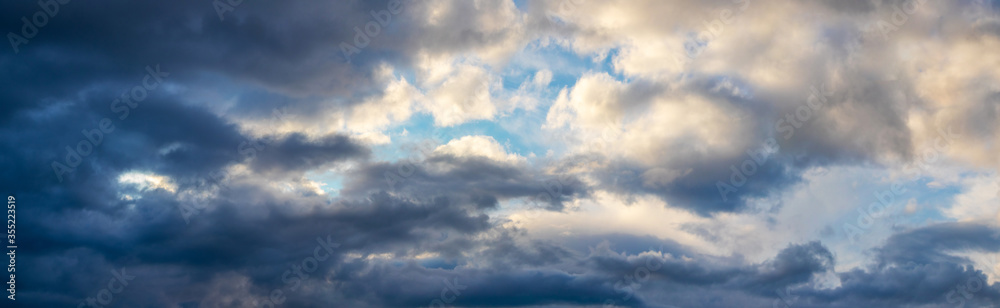 Panorama of the sky with dark clouds on one side and light clouds on the other