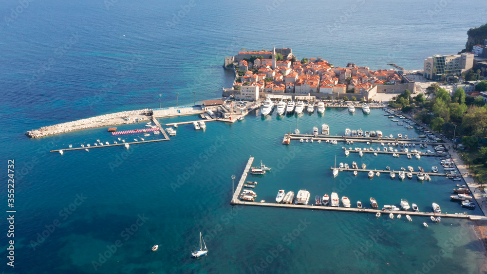 Budva Montenegro - famous summer vacation tourist destination on the coast of turquoise Adriatic sea. Medieval old town and marina for small boats and yachts in the Mediterranean, in south Europe.