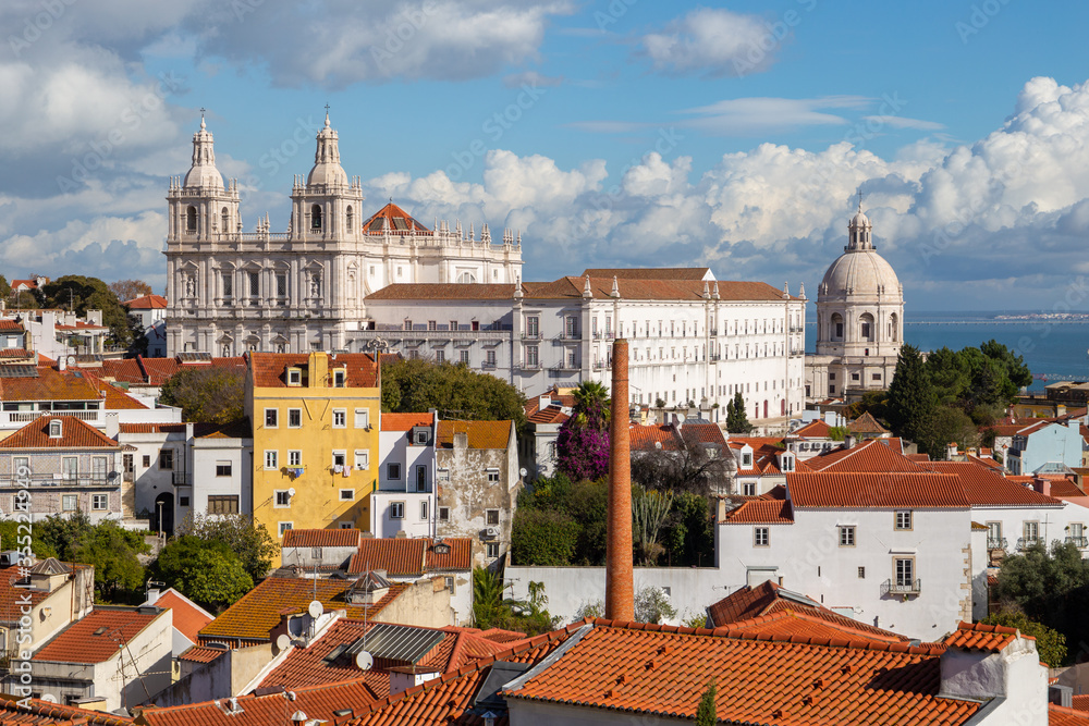 Lisbon, Portugal: Alfama district under cloudy sky on a sunny day featuring Church - Monastery of Sao Vicente de Fora and Santa Engracia (National Pantheon) as famous landmarks and attractions.