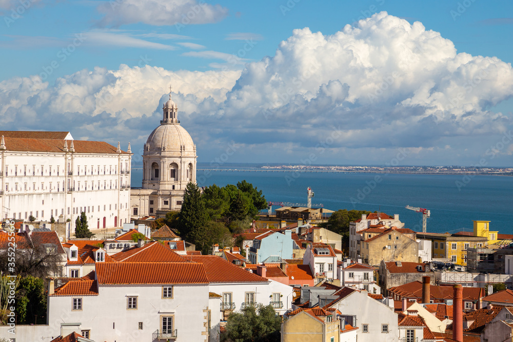 Lisbon, Portugal: Alfama district under cloudy sky on a sunny day featuring Church of Santa Engracia (National Pantheon) as a famous landmark and attraction. Tagus river in the background.
