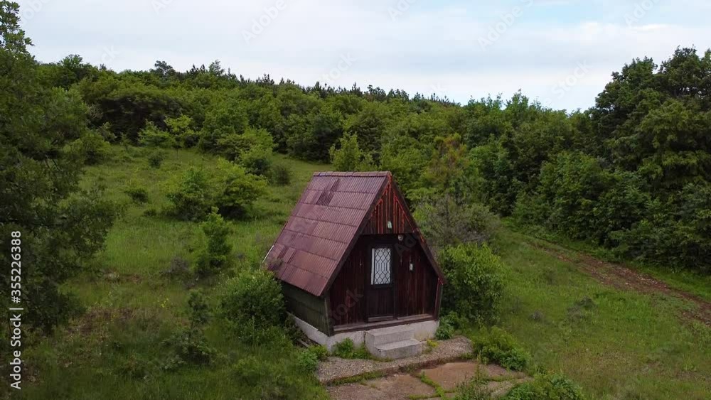 Wooden mountain rural house on the meadow in forest. Aerial drone view Wooden mountain rural house on the meadow in forest. Aerial drone view