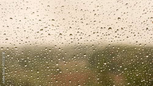 raindrops on the glass close-up. Background texture. Warm jet shades. The summer mood.