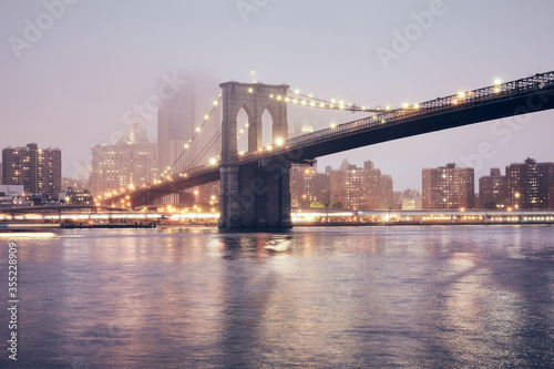 Brooklyn Bridge on a foggy night, color toned picture, New York City, USA.