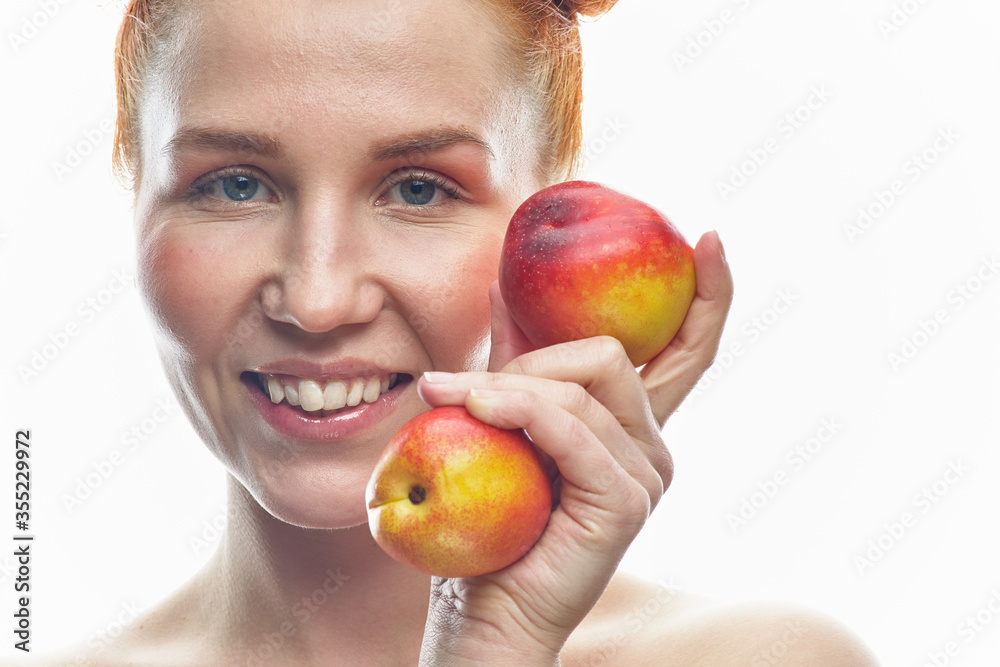 Portrait of a young redhead girl with apples in her hands, with different emotions. Isolated on a white background. Portrait of a young redhead girl with apples in her hands, with different emotions. Isolated on a white background.