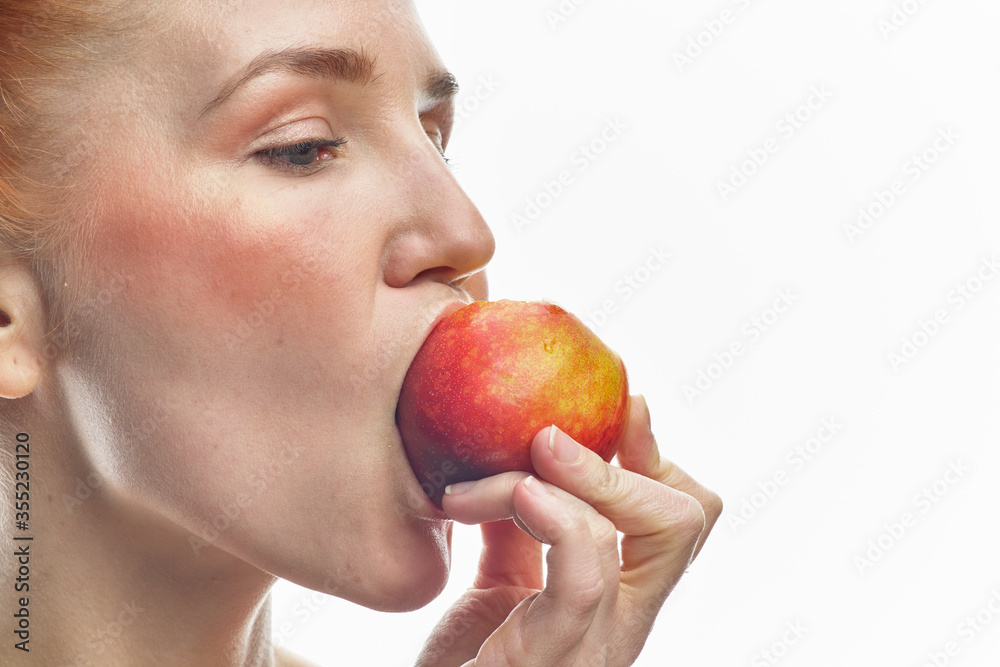 Portrait of a young redhead girl with apples in her hands, with different emotions. Isolated on a white background. Portrait of a young redhead girl with apples in her hands, with different emotions. Isolated on a white background.
