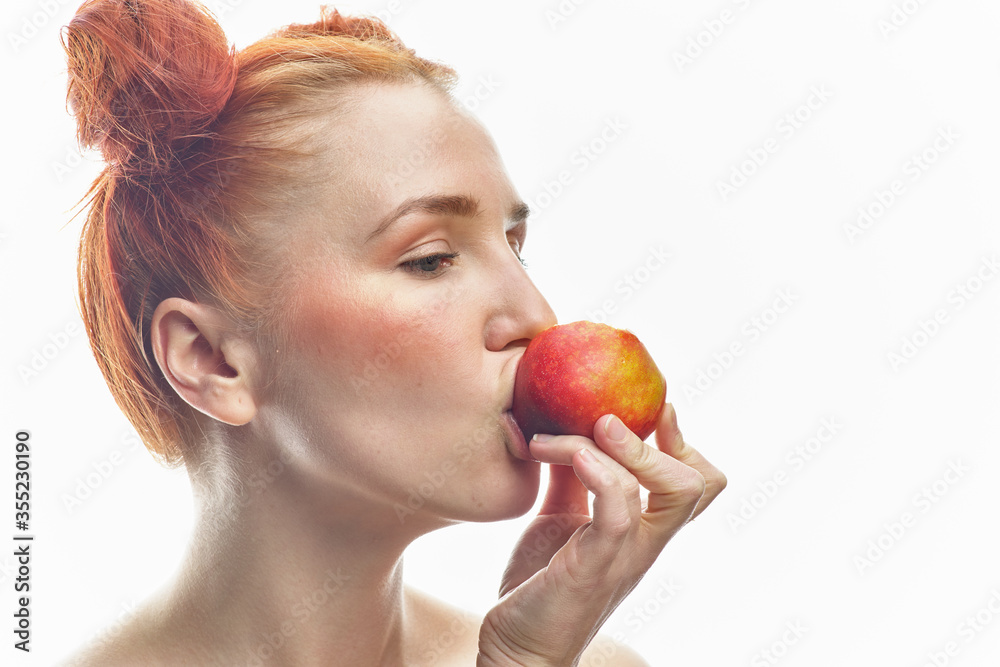 Portrait of a young redhead girl with apples in her hands, with different emotions. Isolated on a white background. Portrait of a young redhead girl with apples in her hands, with different emotions. Isolated on a white background.