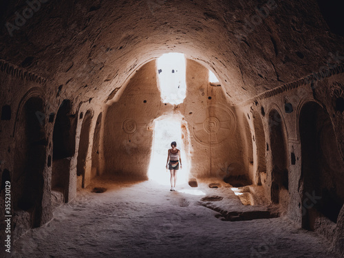 Woman exploring the archaeological remains of a cave church 