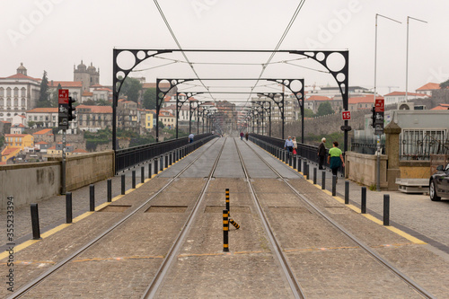 View from the Dom Luiz I Bridge, rails of the city metro. People walk at Dom Luis bridge, Porto, Portugal.