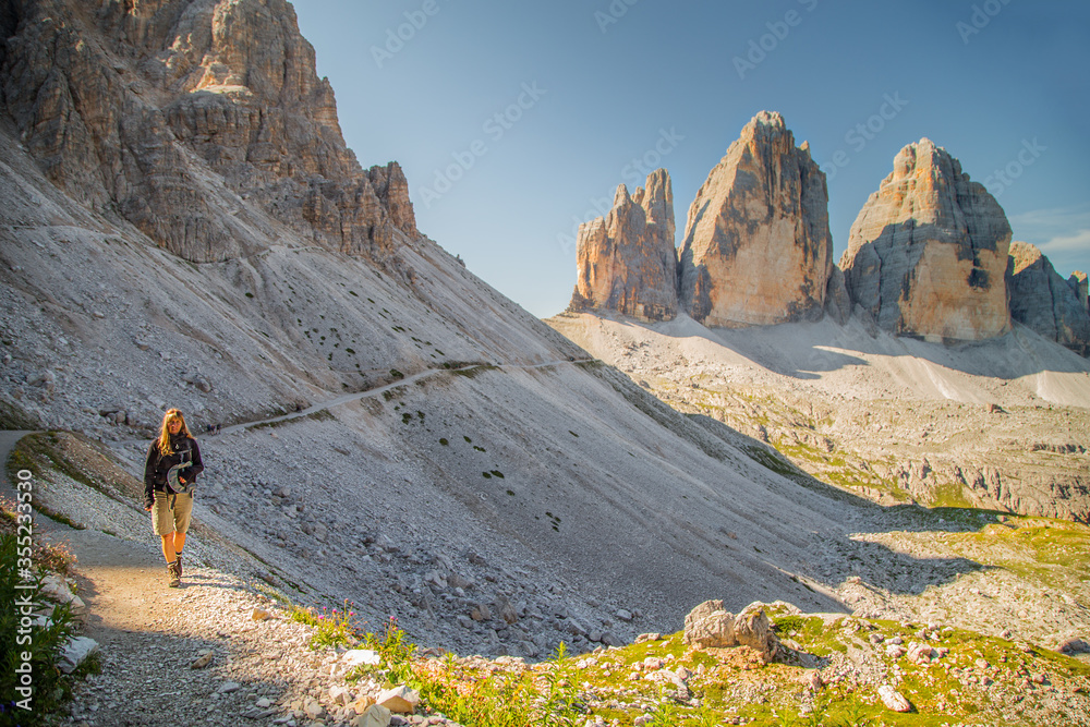Adult hiker on the trekking trail, Tre cime di Lavaredo peaks on the background - Dolomiti Alps, Italy