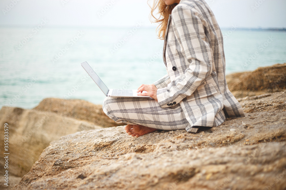 girl with a laptop by the sea. remote work concept