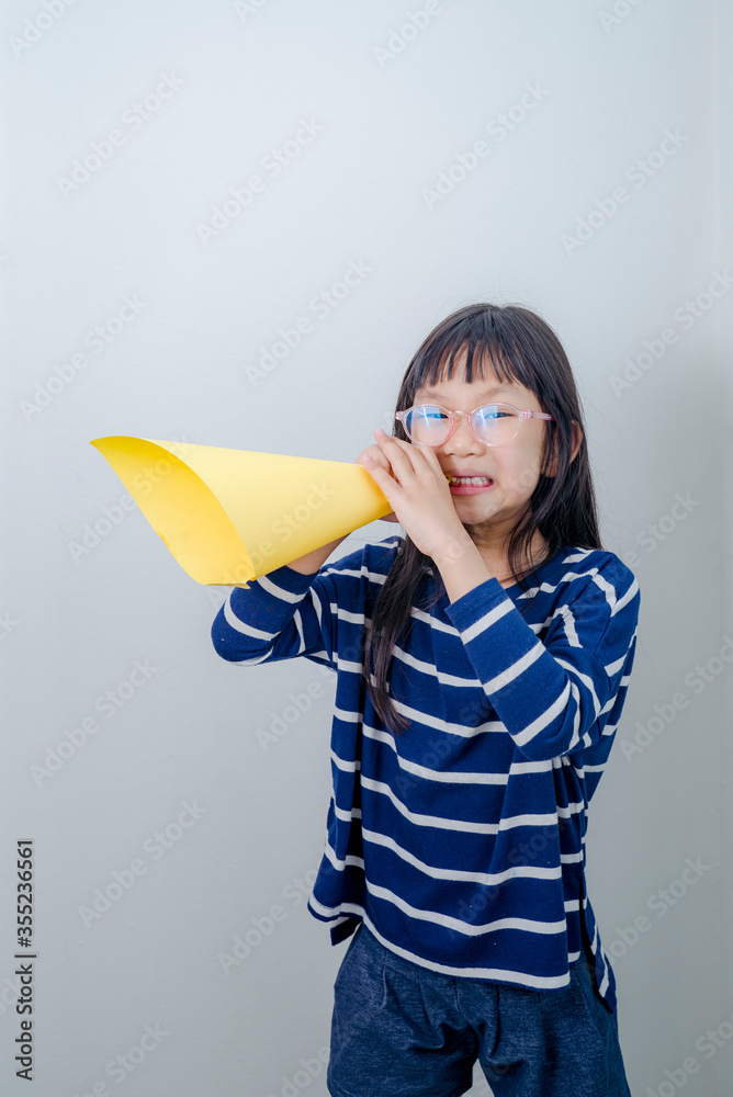 Lettle girl shouting into megaphone with white background. Lettle girl shouting into megaphone with white background.