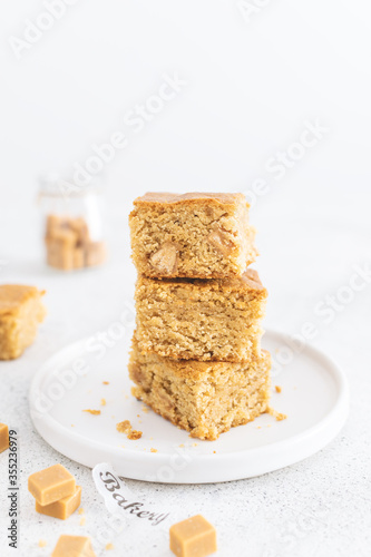 Close up of toffee caramel blondies, sweet pastry on light table