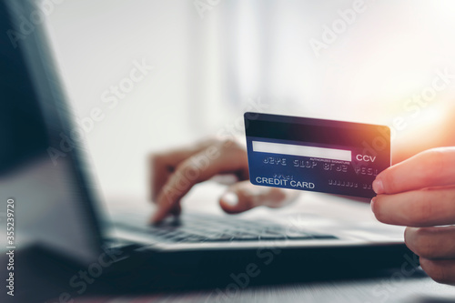 People show their credit cards for the enjoyment of shopping for online shopping by their laptops at home.with copy space. E-payment technology, electronic transactions financial application concept