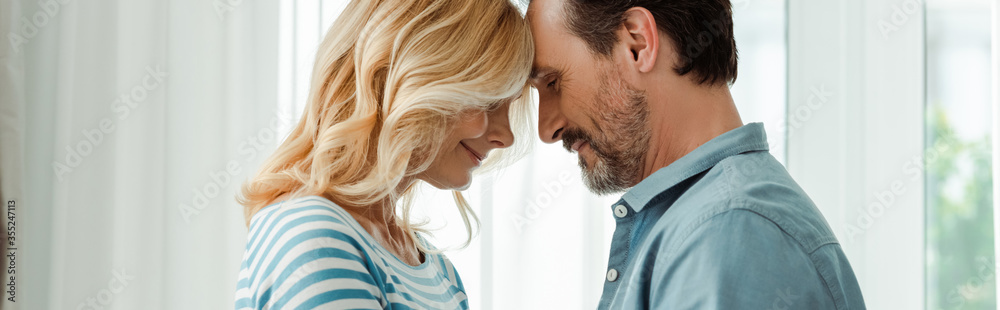 Panoramic crop of mature man smiling near wife at home Panoramic crop of mature man smiling near wife at home